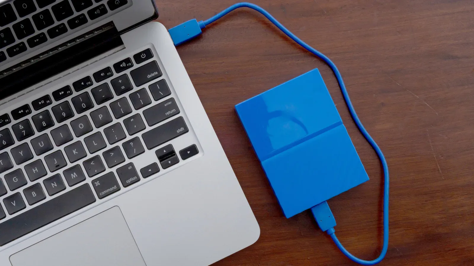 Compact external SSD connected to a gaming laptop by USB-C