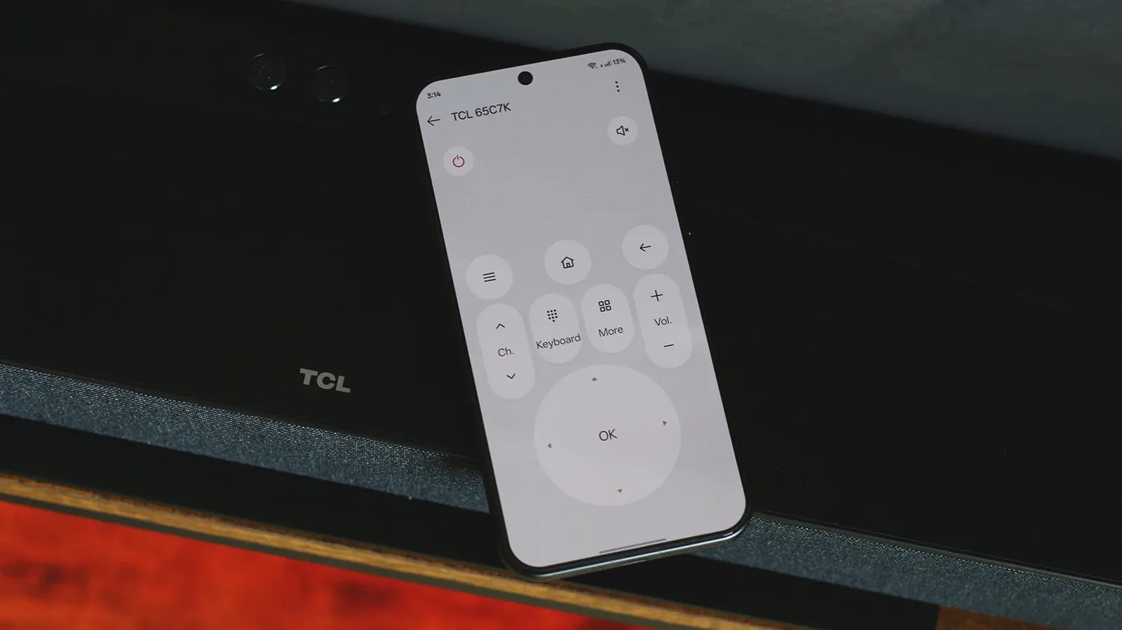 A smartphone displaying remote controls beside a smart TV