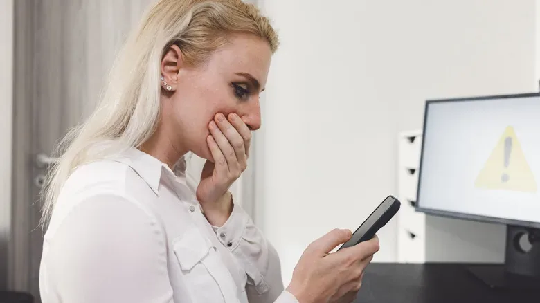 Phone user reviewing app permissions and installed applications