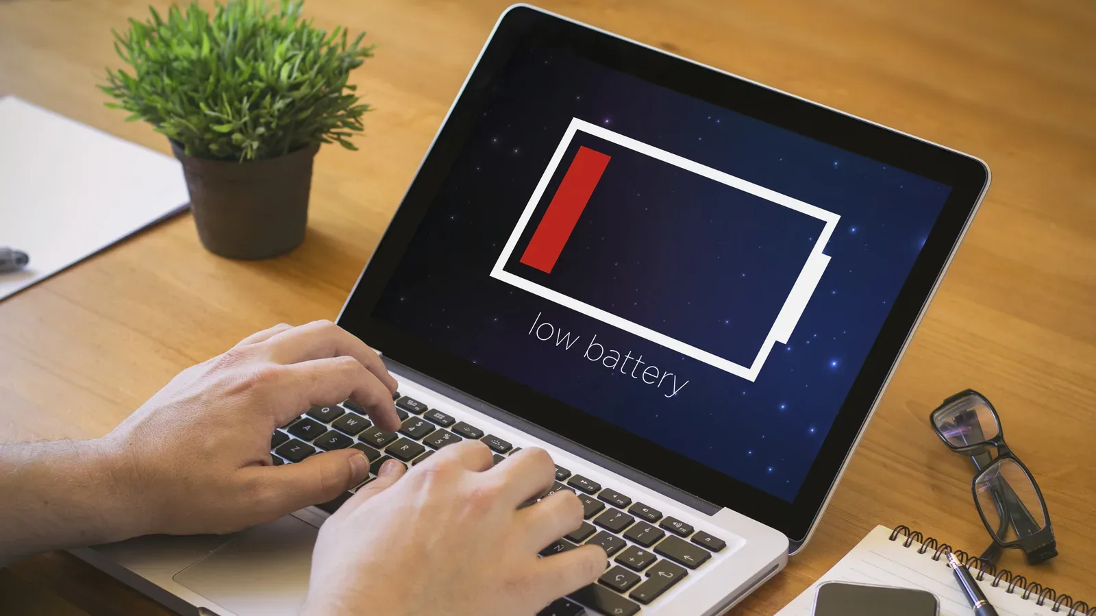 Gaming laptop running on battery power beside its charger