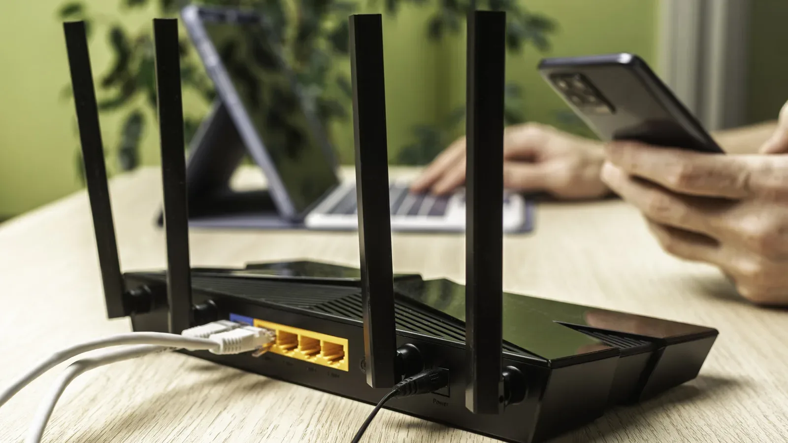 Home router beside a game console illustrating Wi-Fi security settings