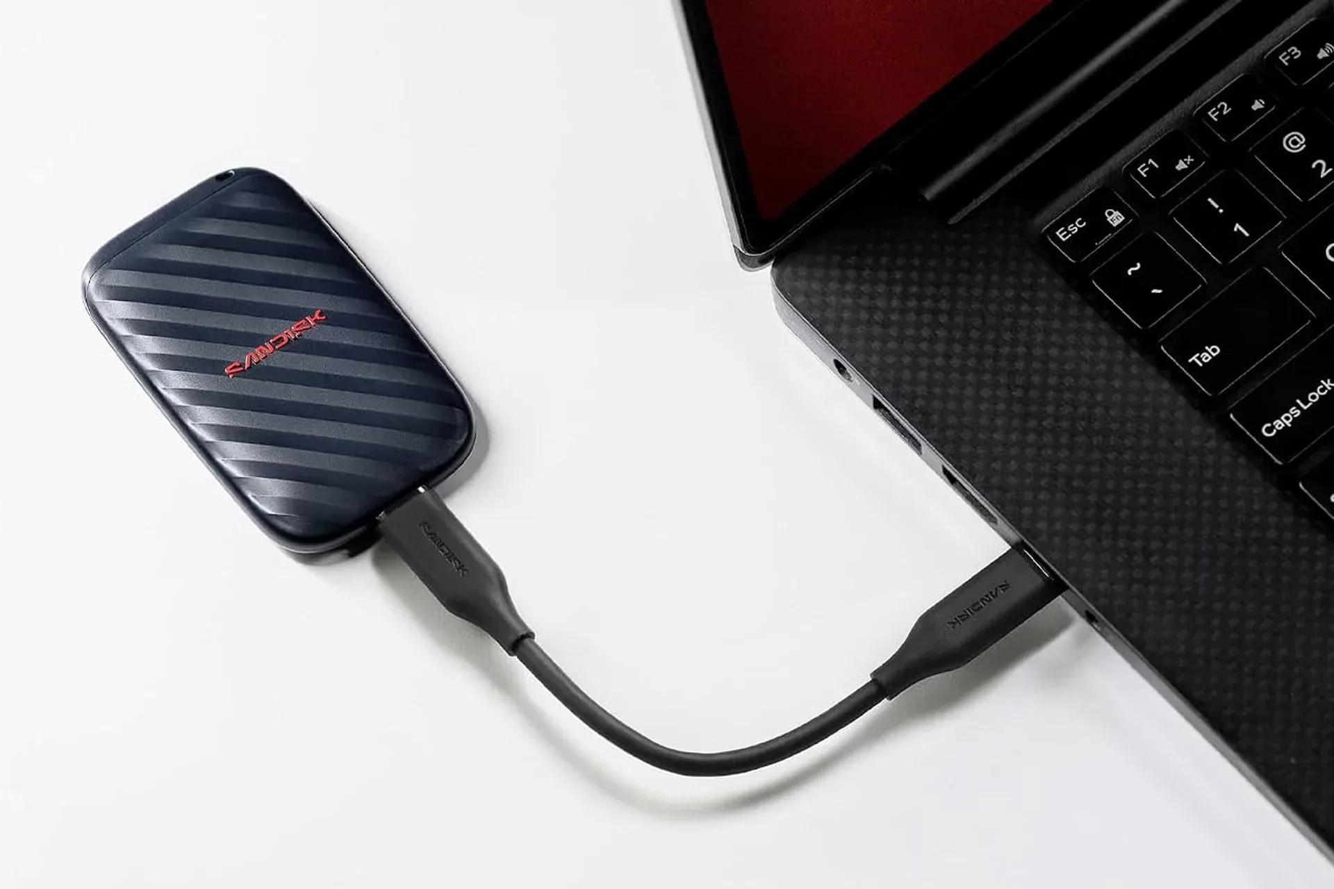 Compact SanDisk 1TB portable SSD connected with a USB-C cable