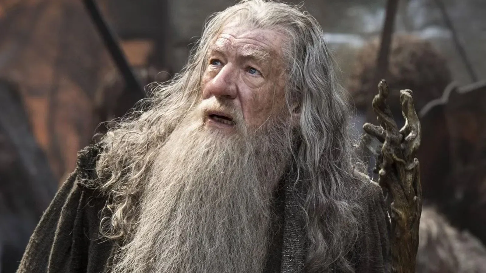Ian McKellen in grey Gandalf-style attire while narrating a music video