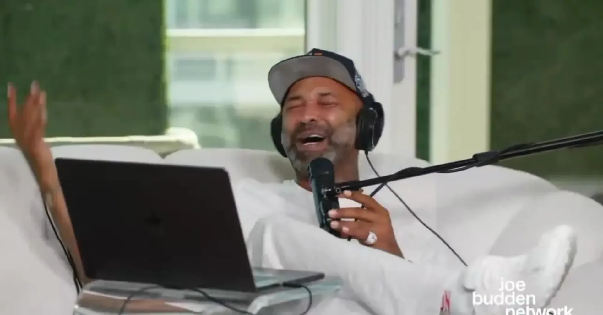 Joe Budden speaking into a podcast microphone