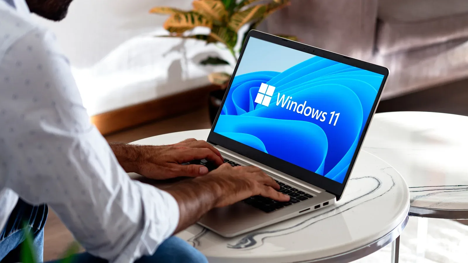 A Windows gaming laptop beside a MacBook on a desk with a controller