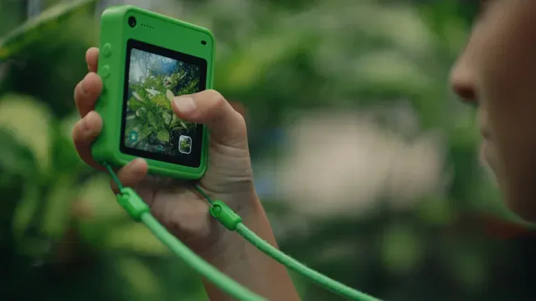 Child using a compact Freckle phone for navigation during an outdoor walk
