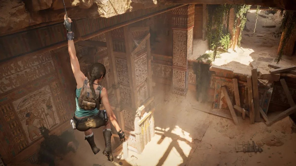 Lara Croft hangs from the ceiling in a half-ruined tomb in Tomb Raider: Legacy of Atlantis