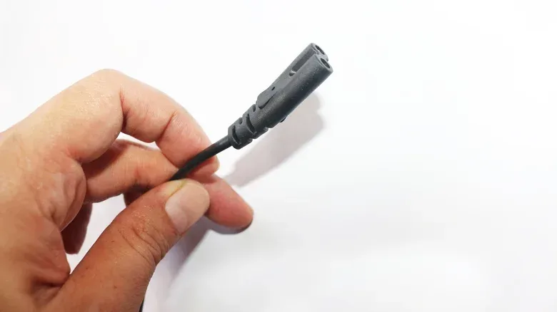 A PlayStation 5 connected with a figure-8 power cable