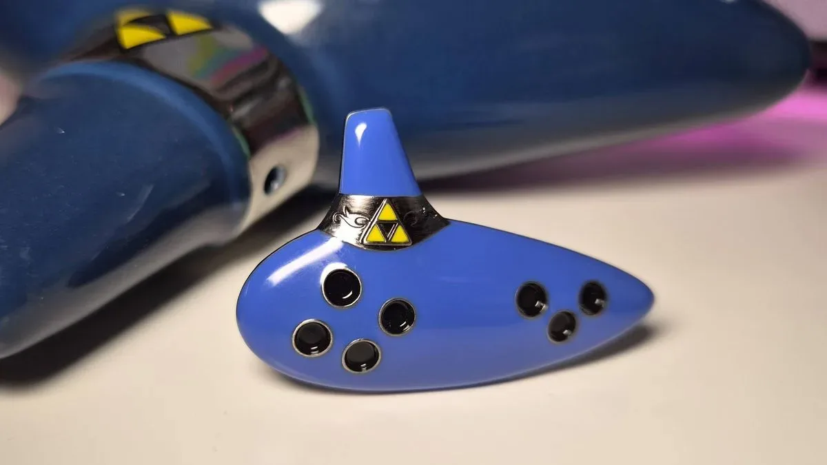 Photo of the Ocarina of Time pin sitting on a white gaming desk.