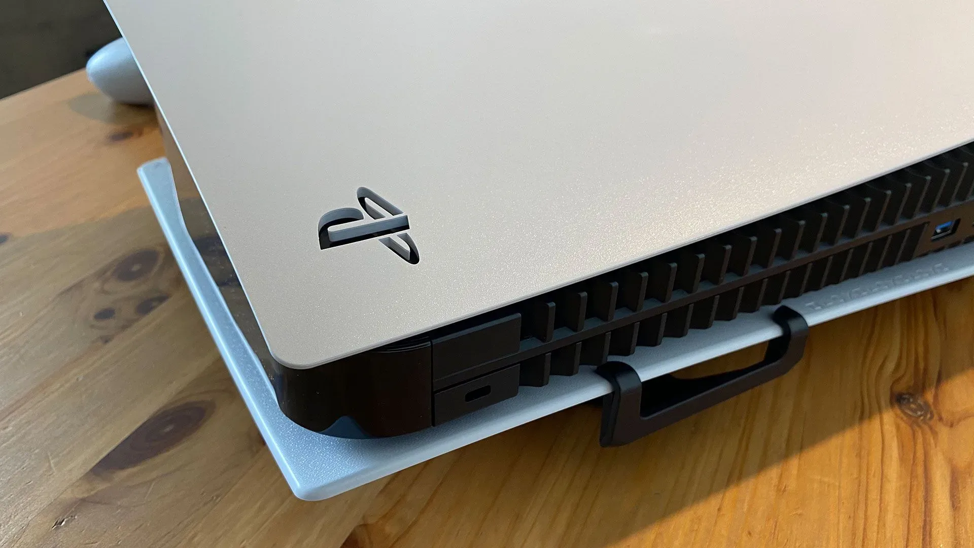 A PlayStation 5 console beside a monitor displaying a Linux desktop interface