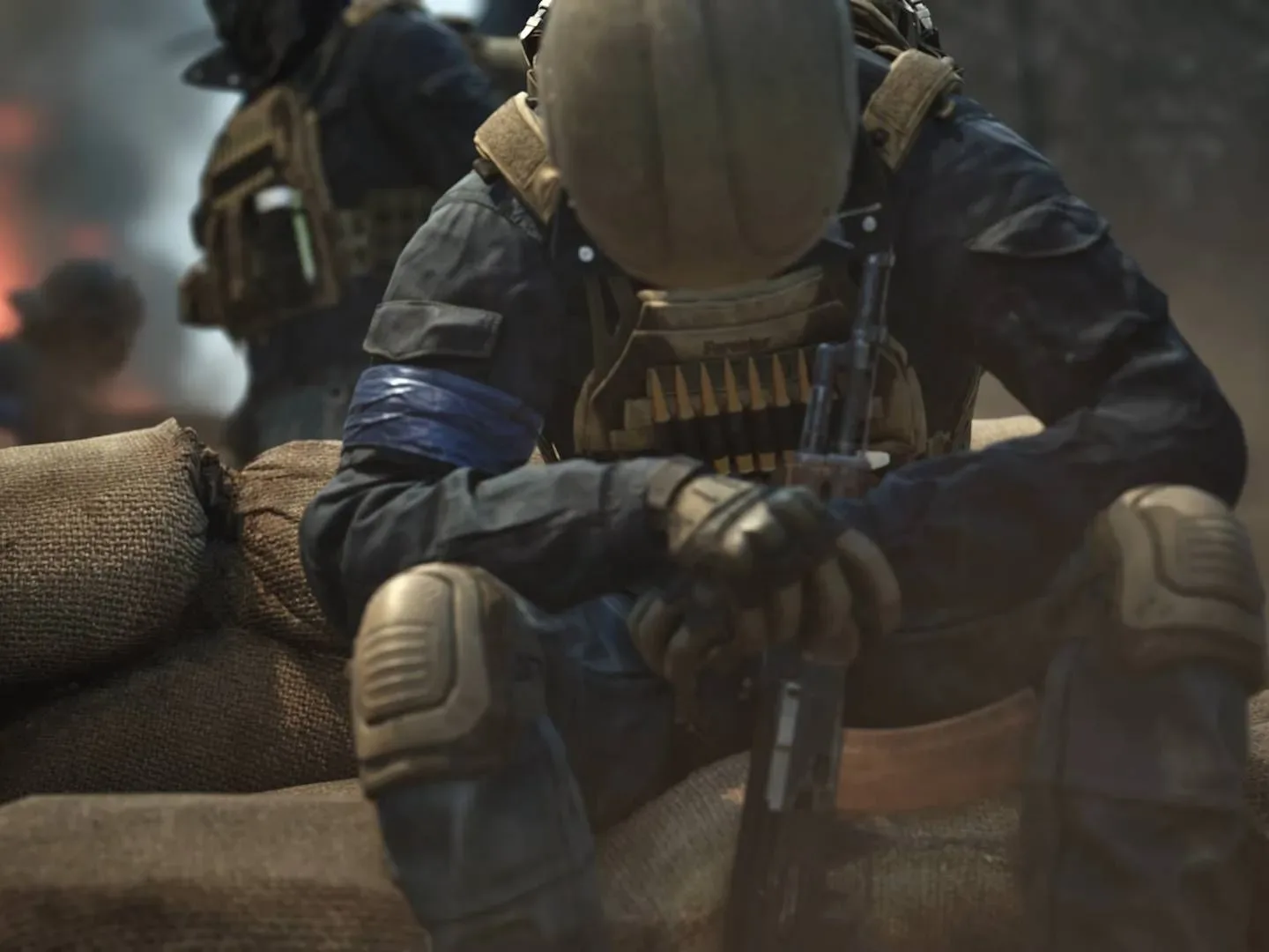 Wardogs solider sitting with hands clasped around rifle