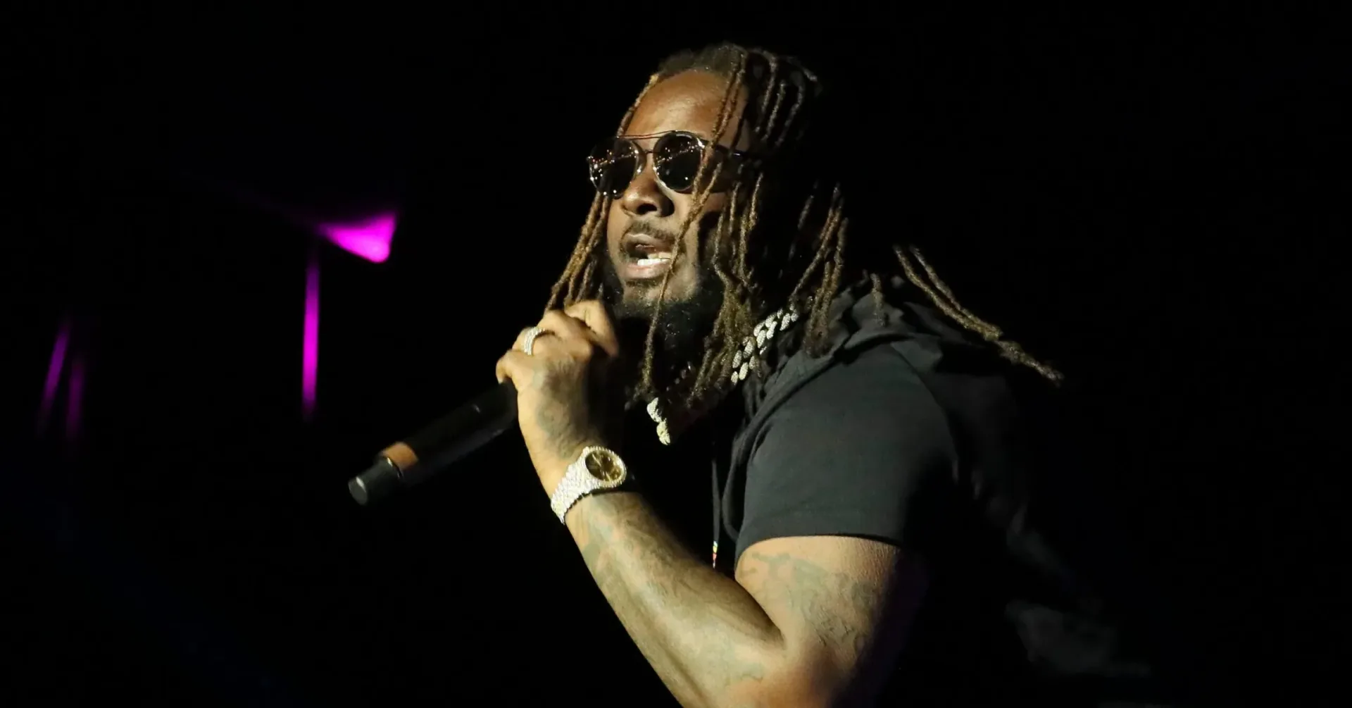 T-Pain performing onstage under concert lighting