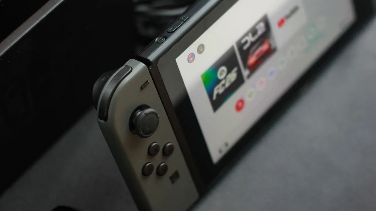Original Nintendo Switch console with Joy-Con controllers beside a dock