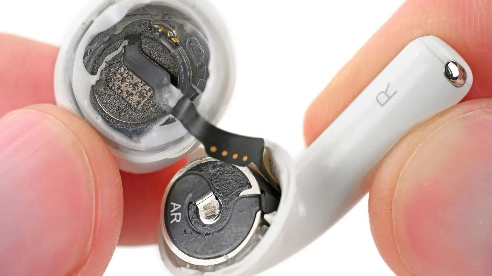 Apple AirPods 5 earbuds beside their charging case