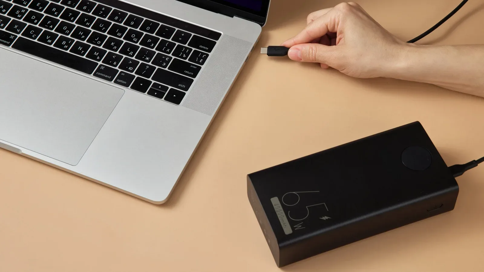 USB-C laptop connected to a power bank beside a charging cable