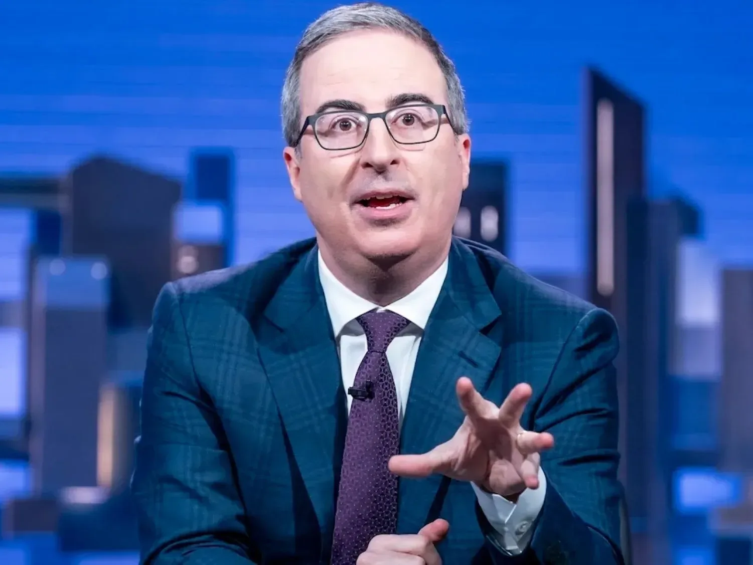John Oliver at the Last Week Tonight desk during a segment about corporate power