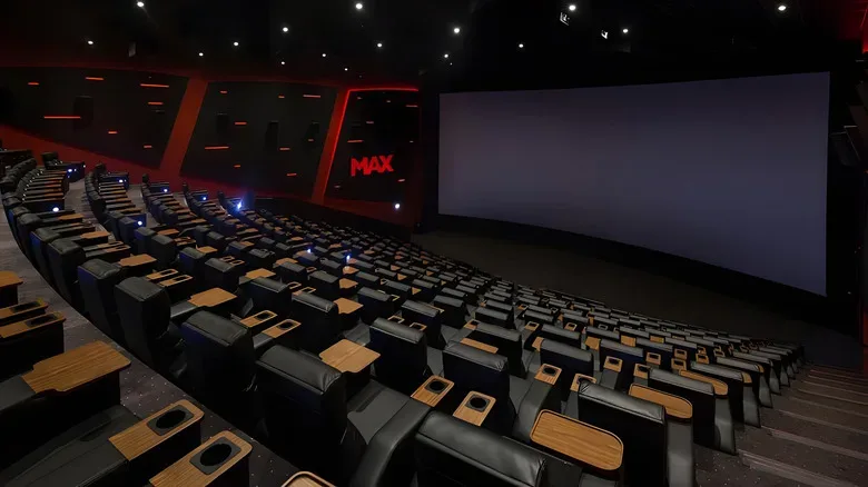 An empty IMAX movie theatre with screen and seats.