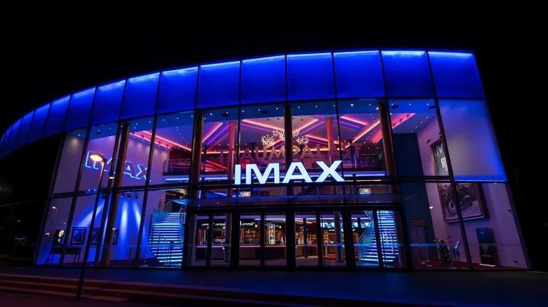 Moviegoers seated beneath a giant-format theater screen
