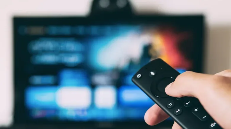 A smart TV home screen alongside a streaming dongle