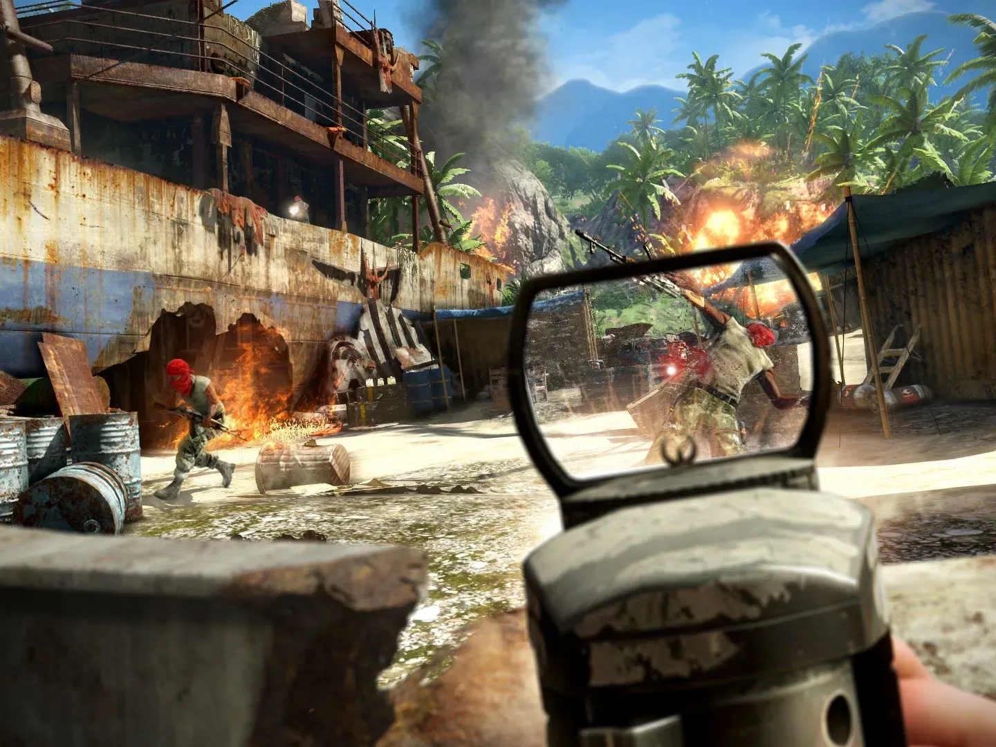 Aiming down laser sights at enemies with a rifle in Far Cry 3. A rusted boat is in the background with a fire happening nearby. Further back is jungle, with an explosion