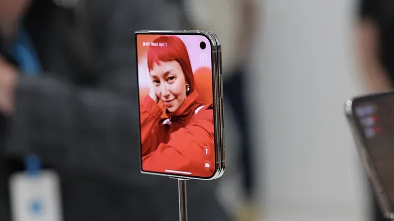 The iPhone Duo's outer display showing a person on the wallpaper, plus various controls.