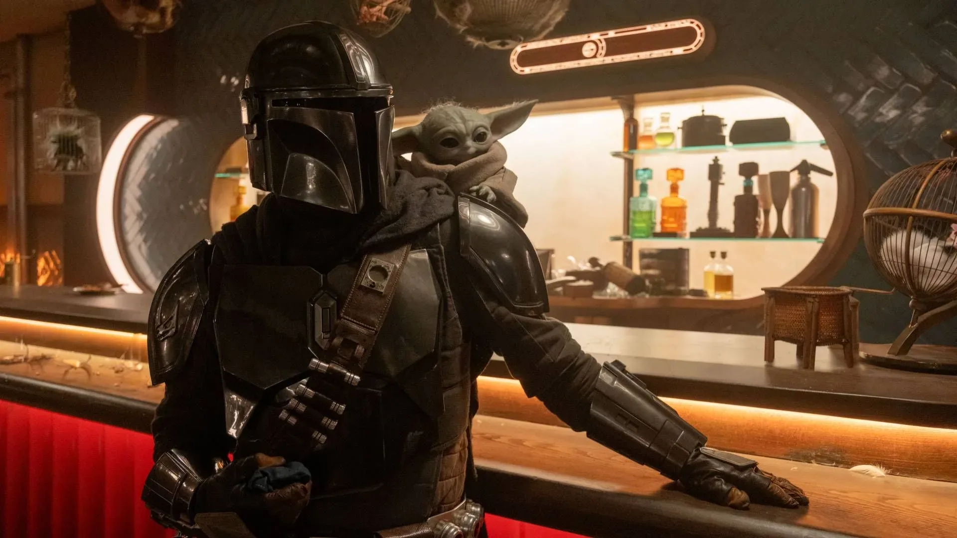 Pedro Pascal's Din Djarin and Grogu stand together at a bar in The Mandalorian and Grogu