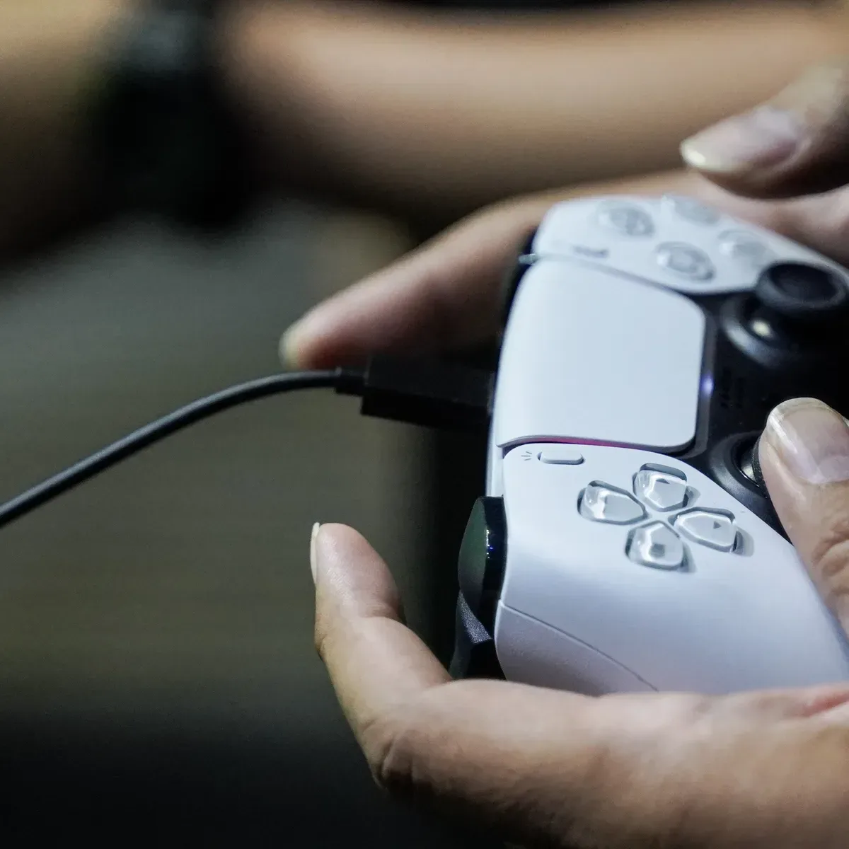 A PlayStation controller concept with a phone held near it for NFC information transfer