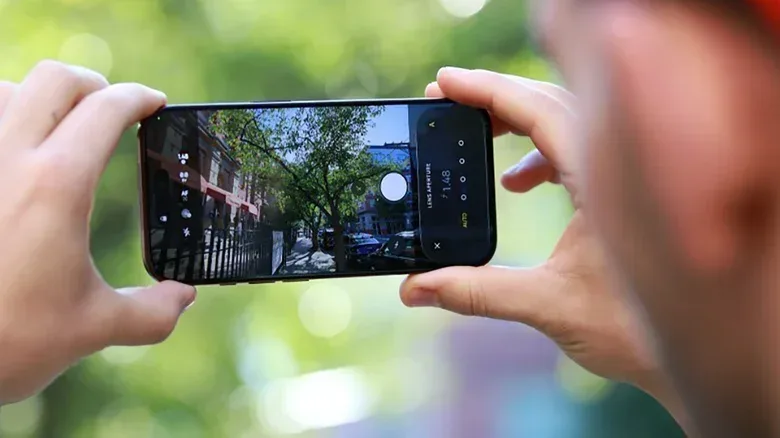 A person holding the iPhone 18 Pro with the camera app open.