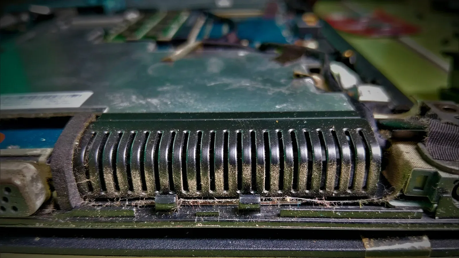 Close-up of a gaming laptop exhaust vent with visible dust buildup