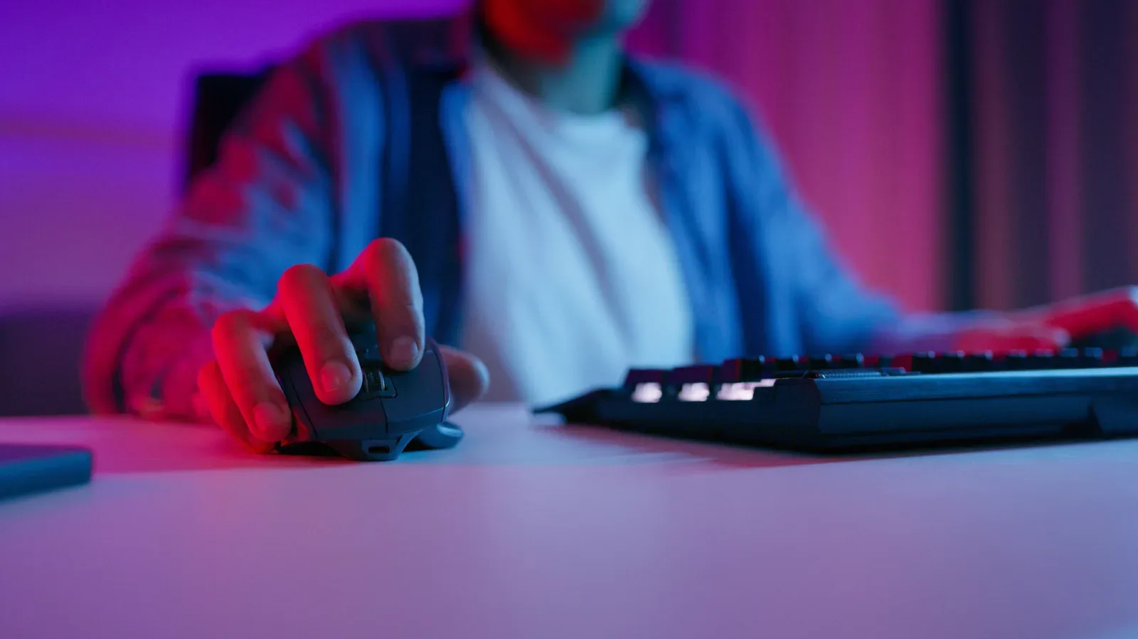 A wired and a wireless gaming mouse beside a PC keyboard
