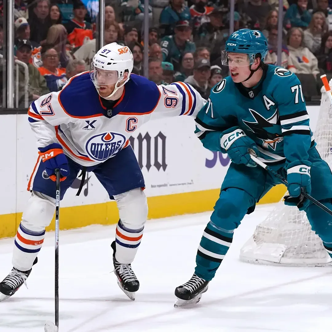 Macklin Celebrini skating for the San Jose Sharks against Connor McDavid and the Edmonton Oilers