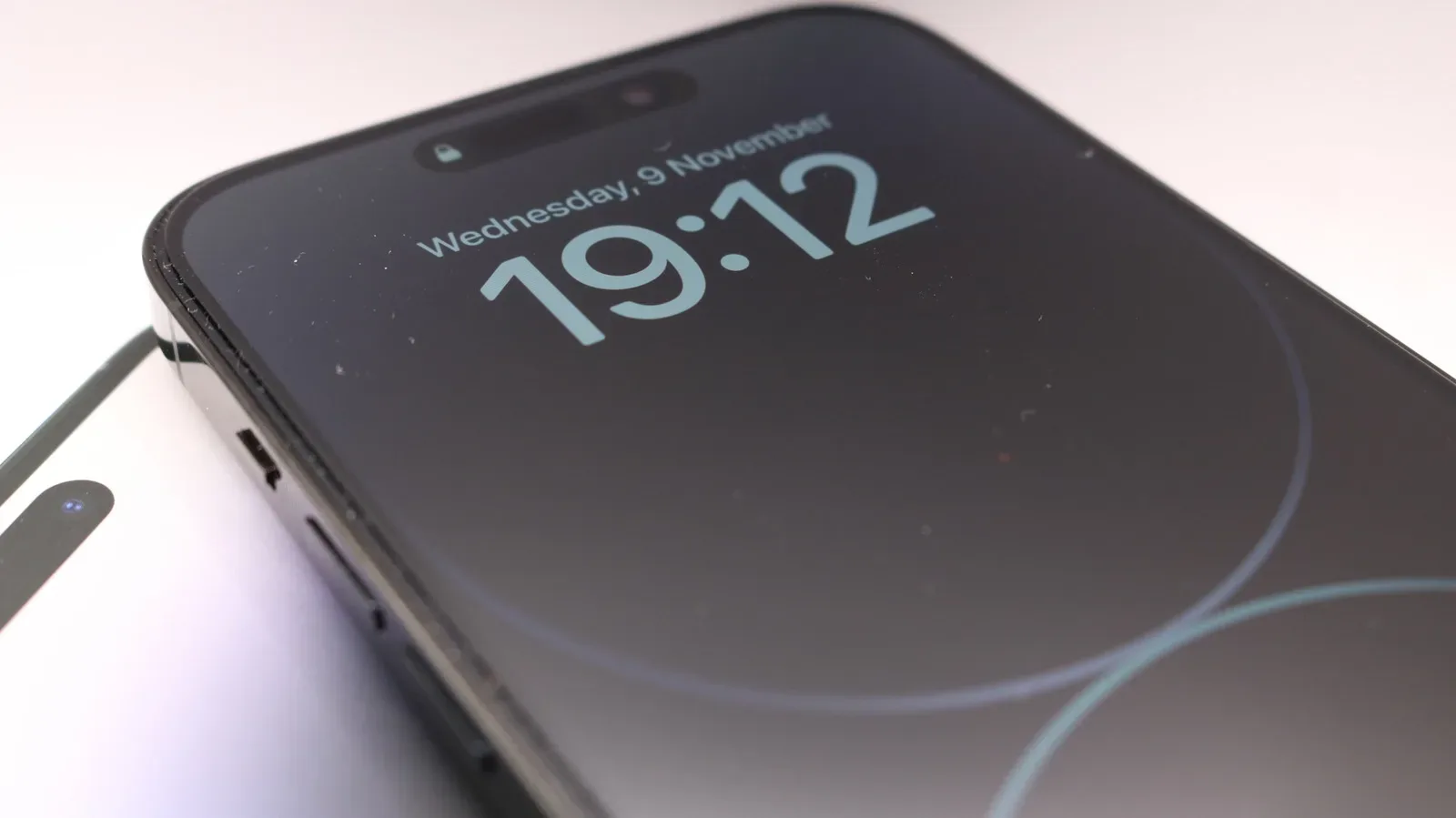 An iPhone showing a dimmed Always-On Display Lock Screen with the time and notifications visible