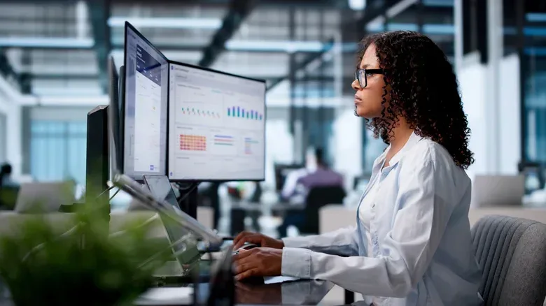 An ergonomic multi-monitor desk setup with displays positioned at eye level