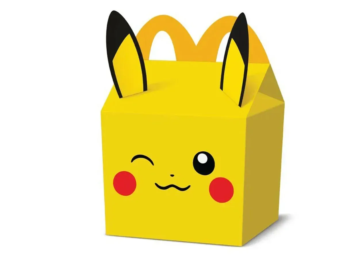 A Pokémon promotional Pikachu card with Pikachu reaching toward a burger and vegetables
