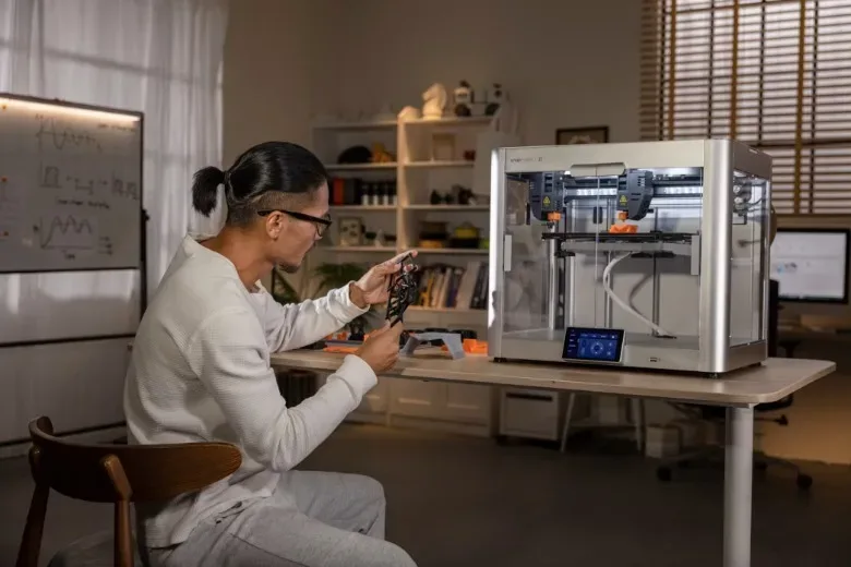 A man prototypes using a 3D printer.