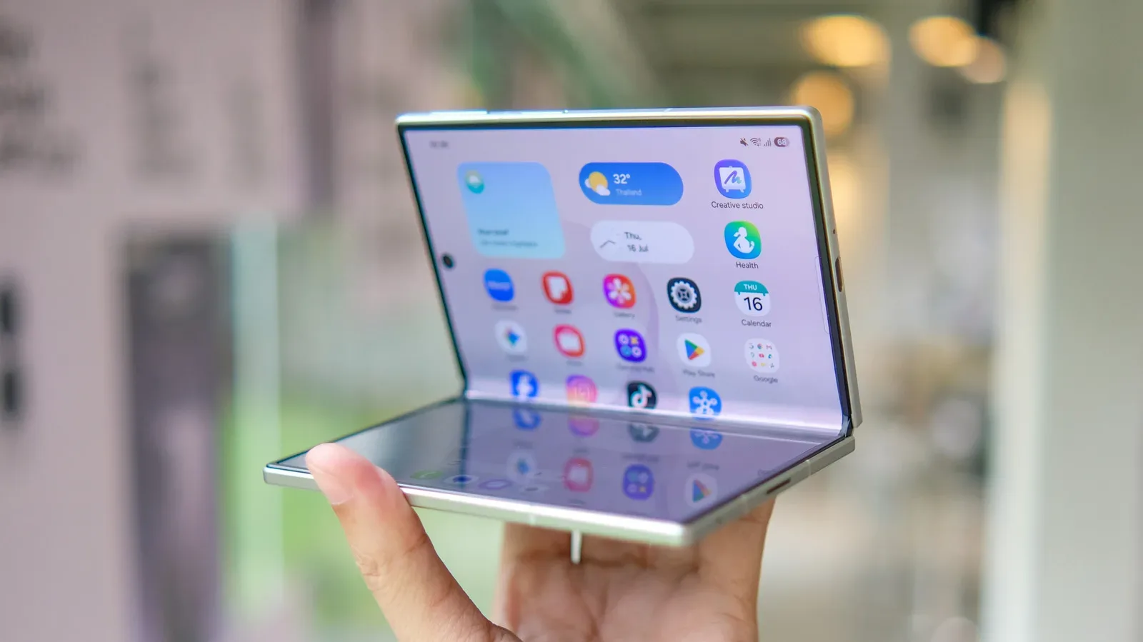 A book-style foldable phone open on a desk with a raised rear camera module