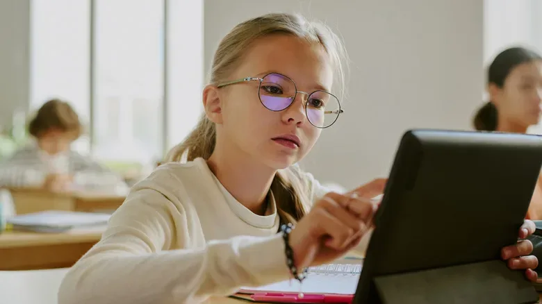 A girl using a tablet in the classroom.