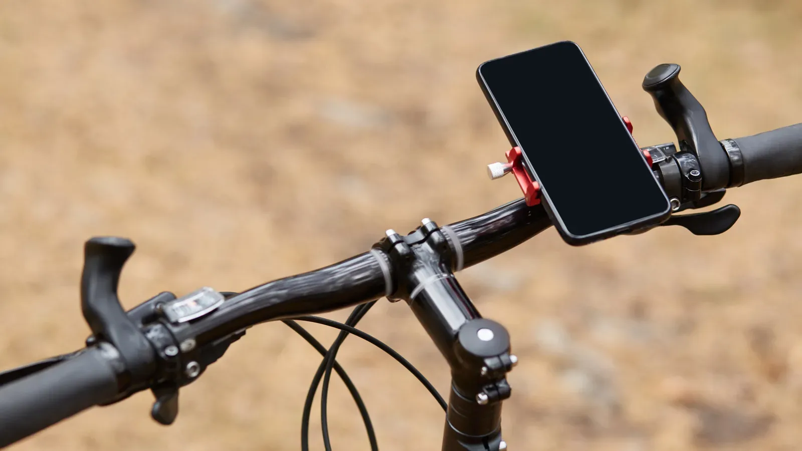 A smartphone mounted to bicycle handlebars displaying a cycling route