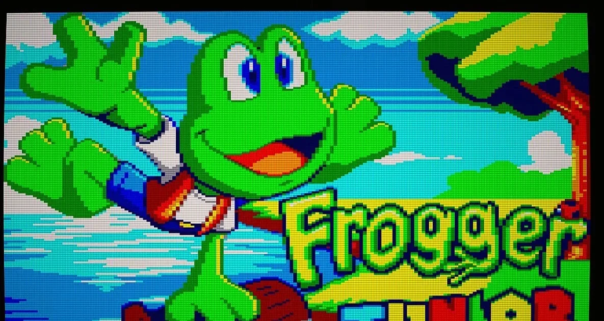 Frogger Junior river section with drifting logs, crocodiles and shoreline houses