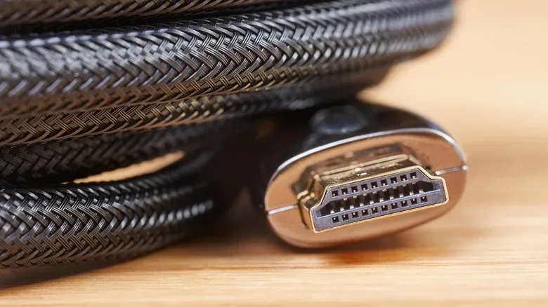 A closeup of a wound-up HDMI cable showing its male end with a gold connector.