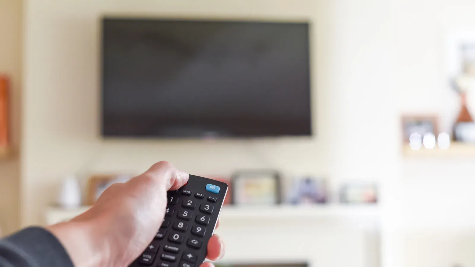 An OLED smart TV in standby mode with a blank screen