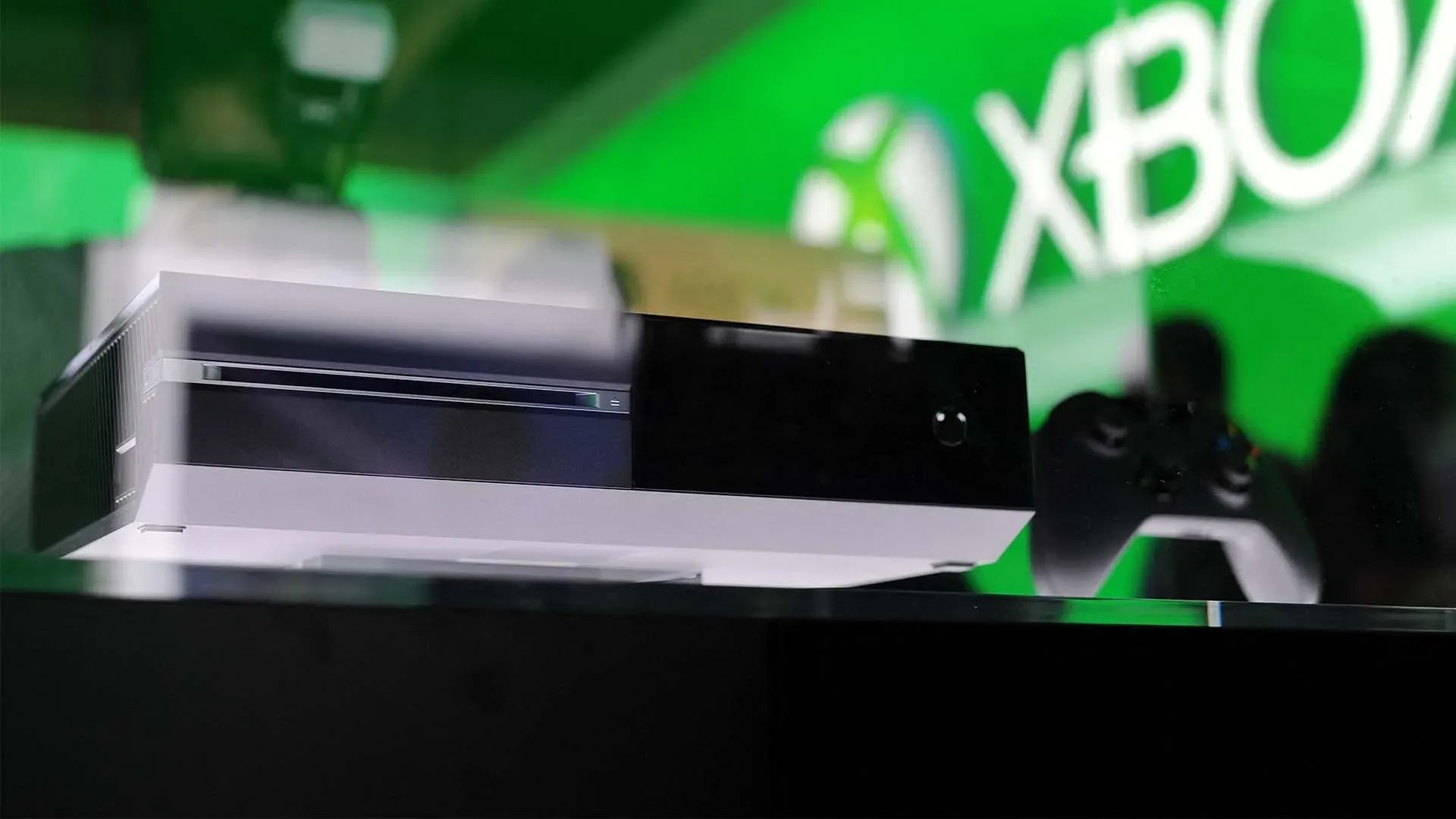 An Xbox game disc beside a console, illustrating physical-to-digital game conversion