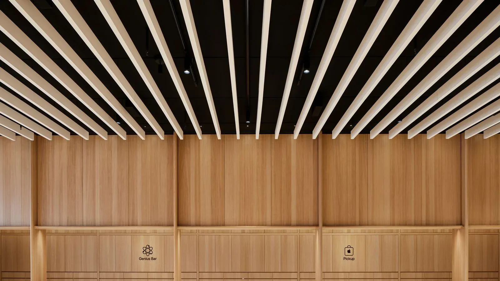 An Apple Store interior with wood service counters and product tables