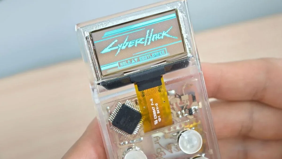 Arduview transparent handheld console showing its clear OLED screen and visible internal electronics