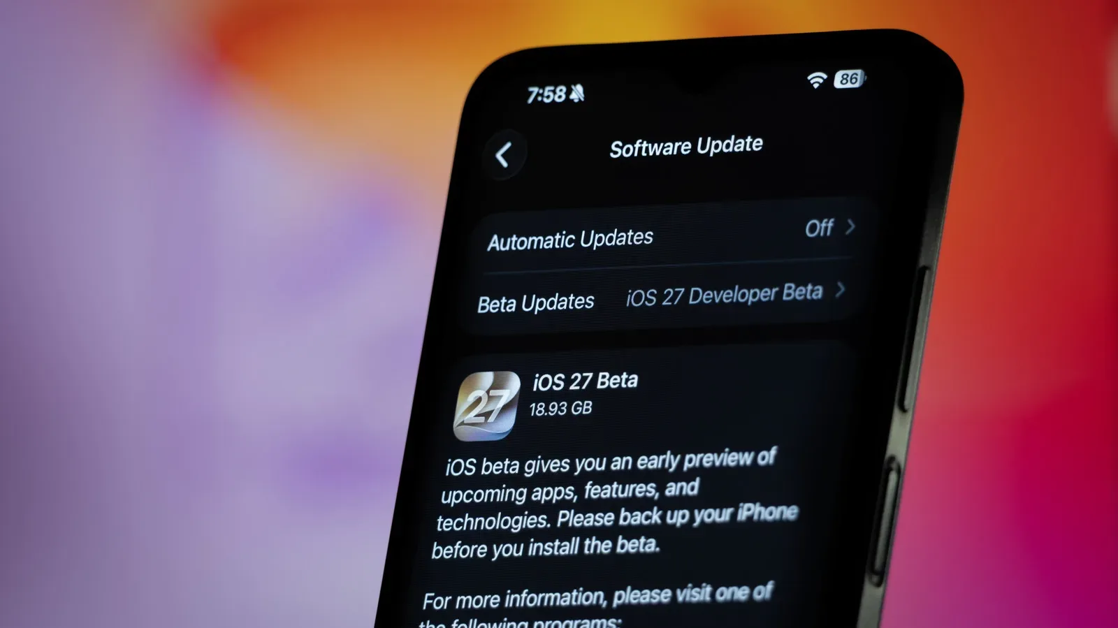 An iPhone connected to a Mac for an archived encrypted backup before an iOS public beta update