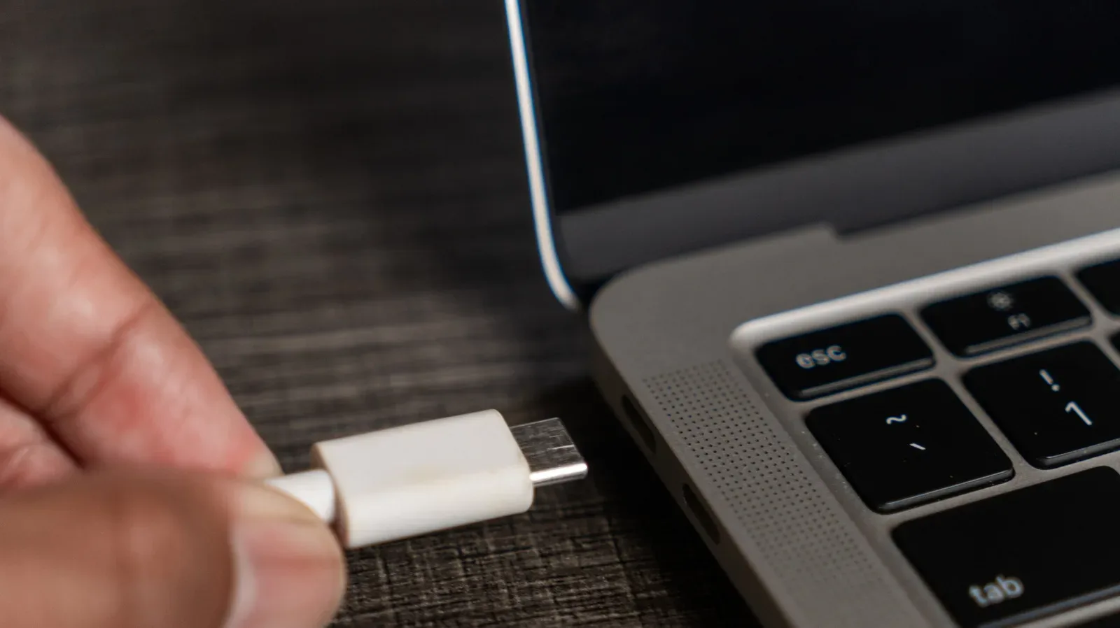 USB-C laptop port beside a DisplayPort cable and gaming monitor