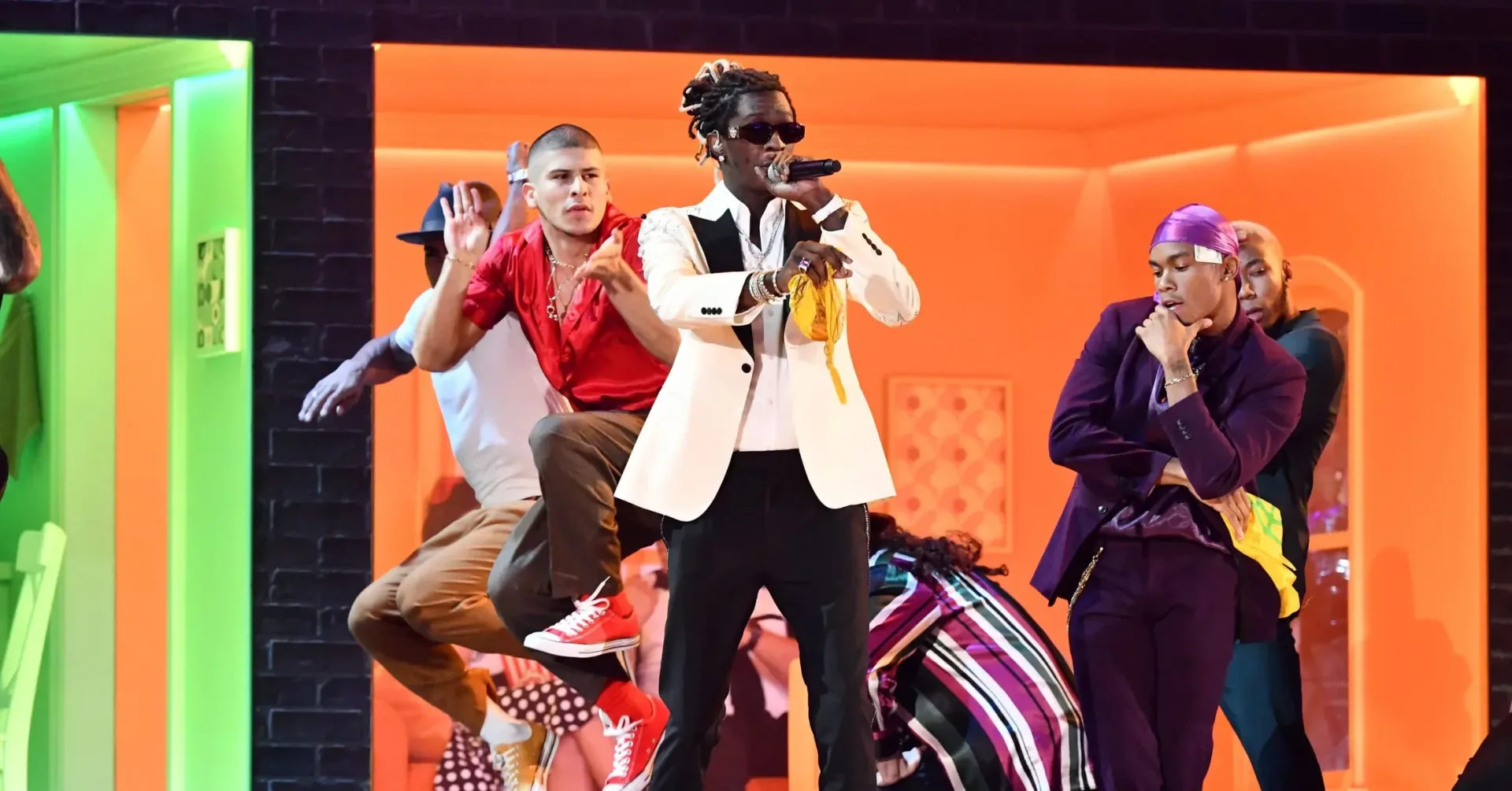 Young Thug performing on stage under concert lighting