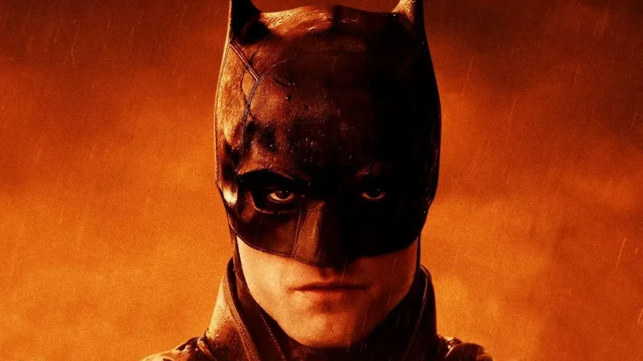 A rain-soaked Gotham City skyline with the Bat-Signal