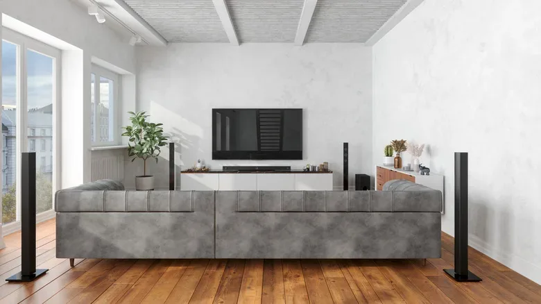 A subwoofer placed beside a home-theater cabinet with room around its port