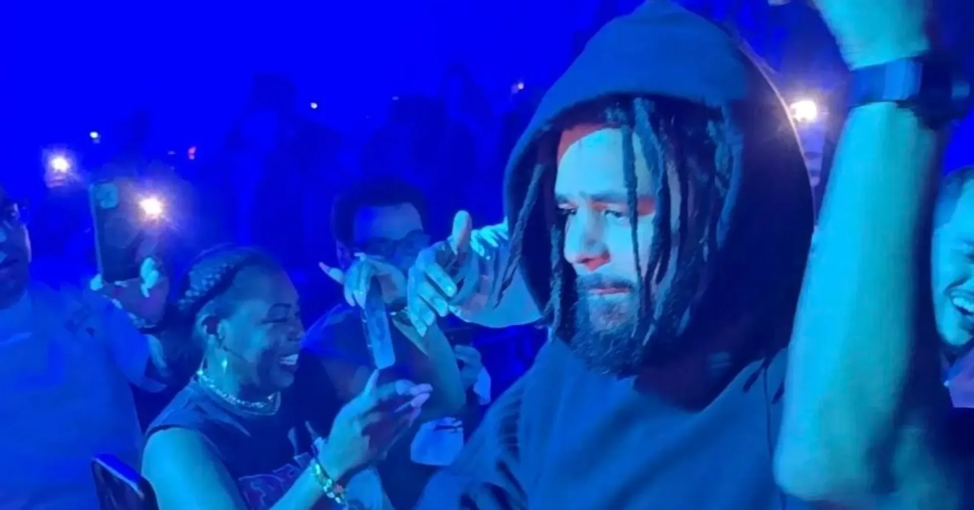 J. Cole performing under stage lights